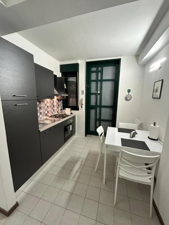 a kitchen with a white table and a black refrigerator at Casa Jaya Taormina in Taormina