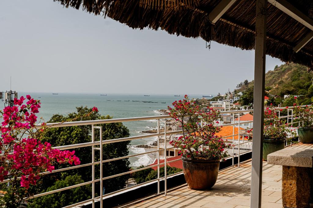 a balcony with flowers and a view of the ocean at Ananas Beach Hotel in Vung Tau