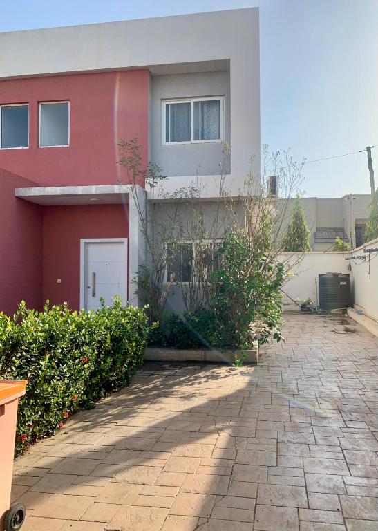 a red and white house with a driveway at Stylish and spacious room in a quiet environment in Dawhwenya
