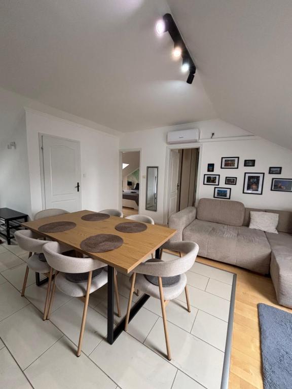 a living room with a wooden table and chairs at Sunrise 2 Apartment in Hajdúszoboszló