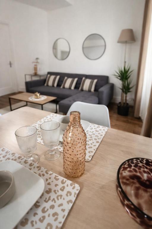 a wooden table with a vase on top of it at Le Nid De Demolombe in Caen