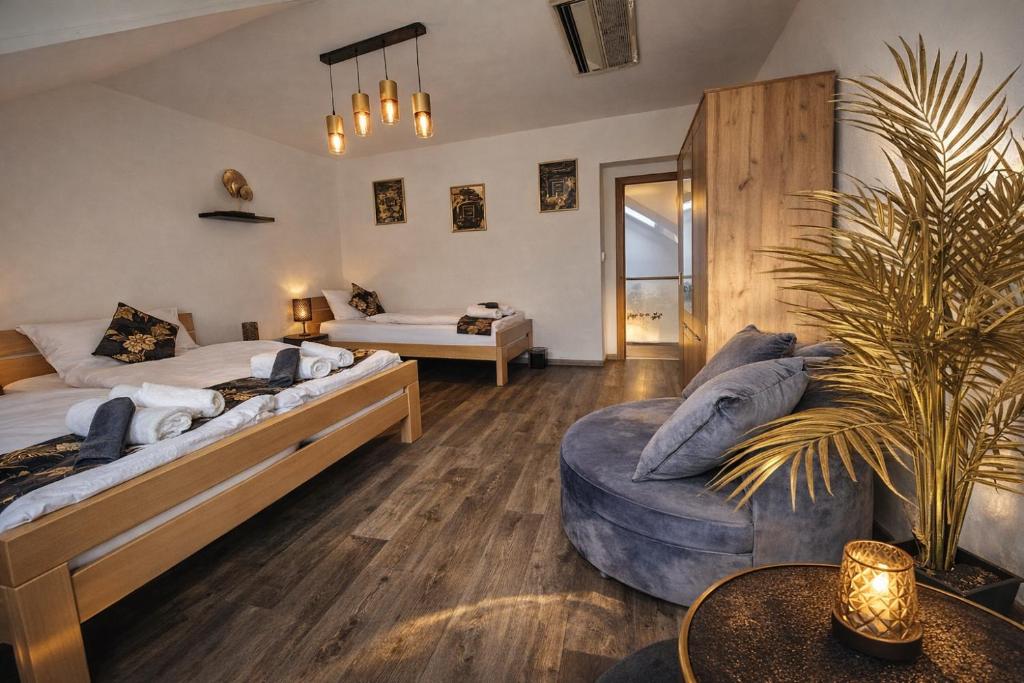 a bedroom with a bed and a couch and a table at Fleiš Residence villa - jacuzzi included in Most