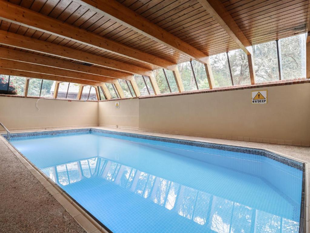 an empty swimming pool in a building with windows at Watermouth Castle, Harbour Apartment in Ilfracombe