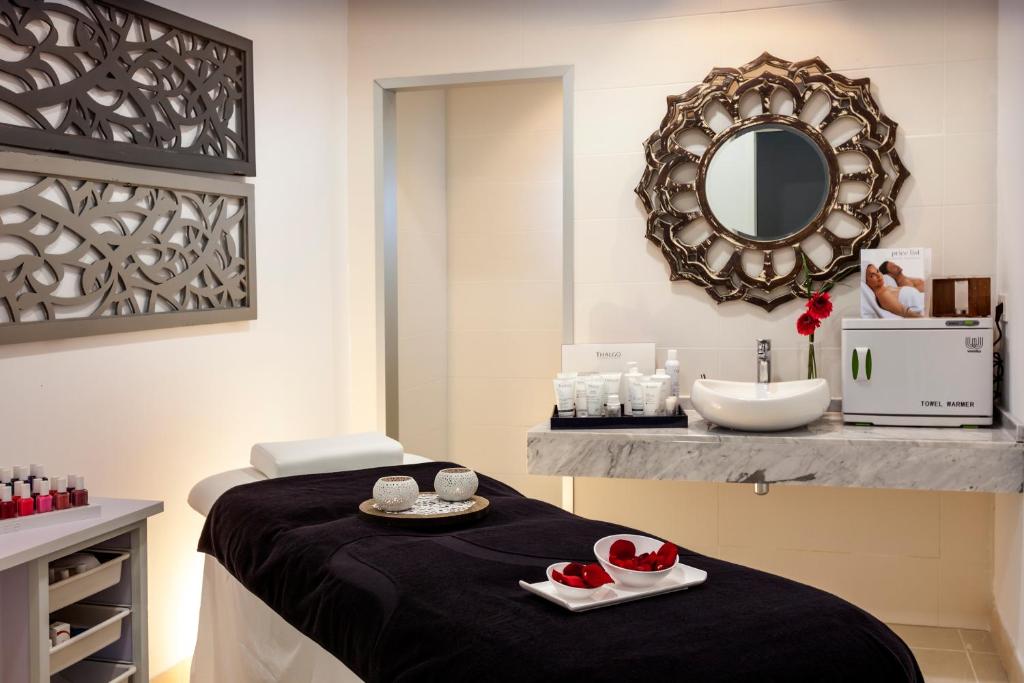 a spa room with a massage table and a sink at Barceló Corralejo Sands in Corralejo