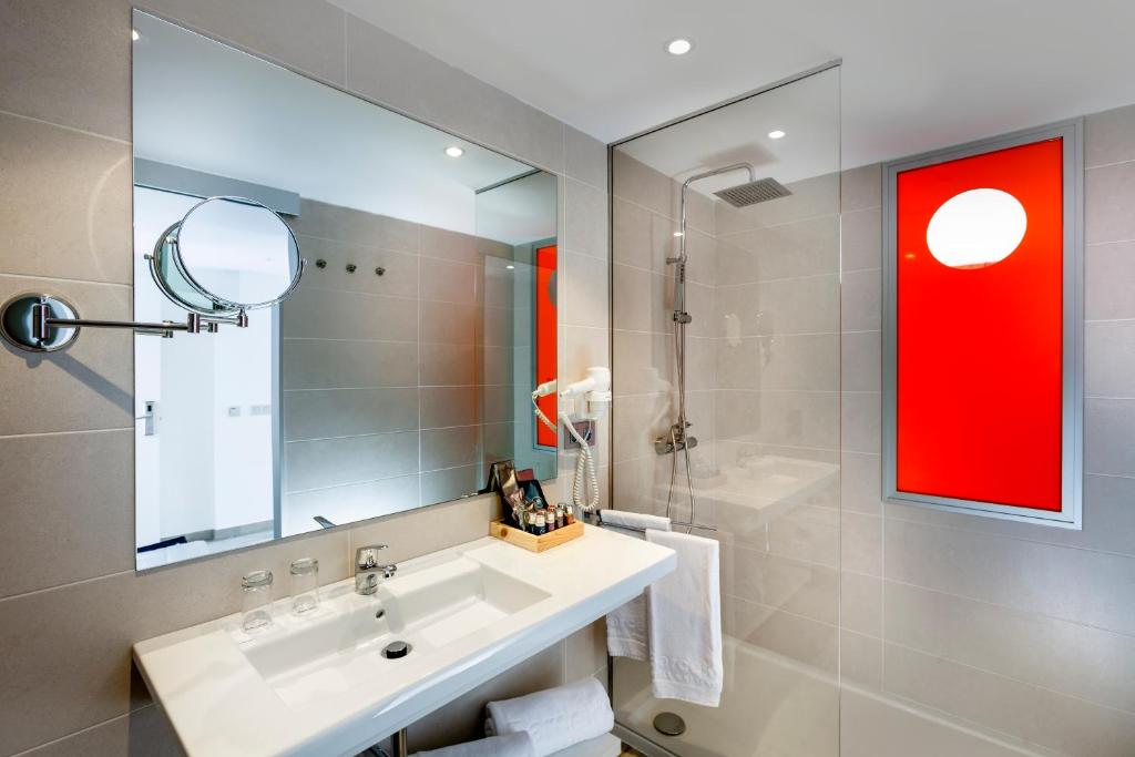 a bathroom with a sink and a mirror at Barceló Corralejo Sands in Corralejo