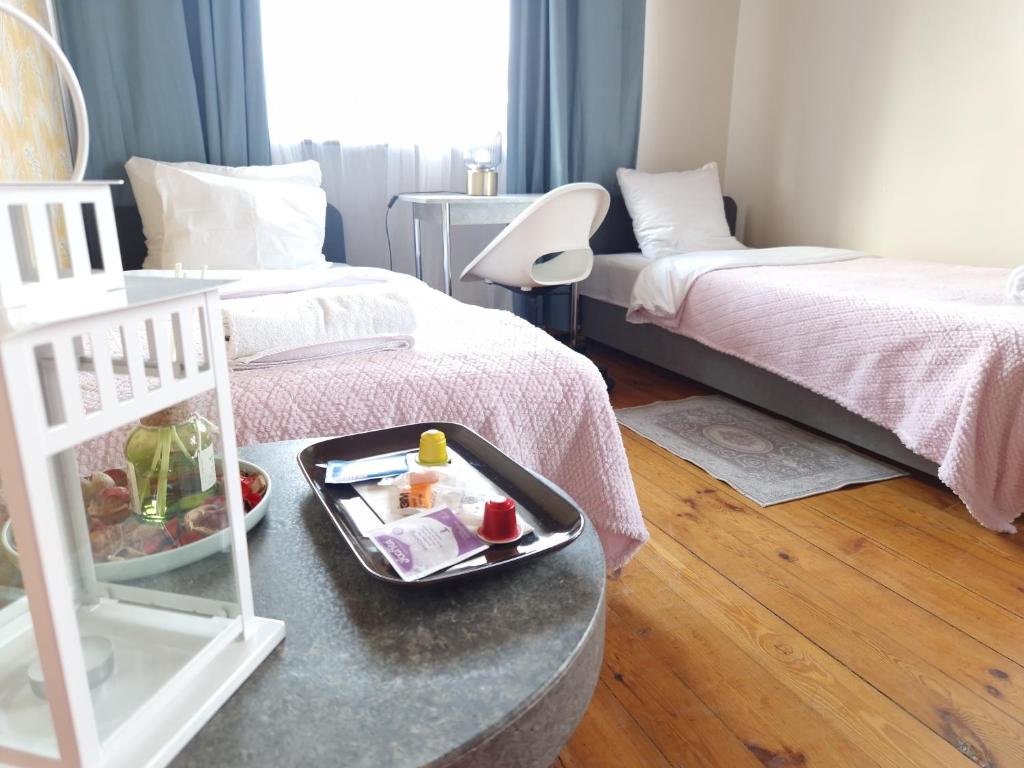 a room with two beds and a tray of food on a table at Promień 4 by Zen4Guest - Biskupin in Wrocław