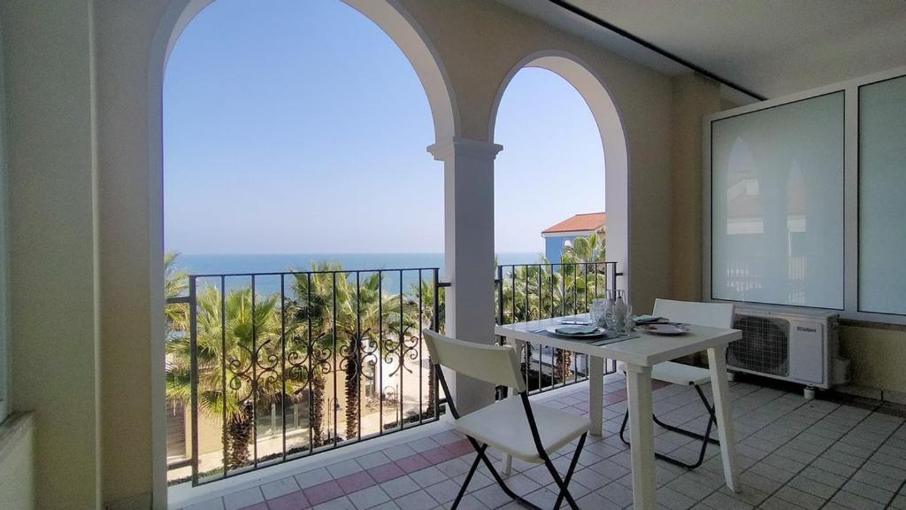 a balcony with a table and a view of the ocean at Monolocale DIRETTAMENTE SUL MARE cod 509 in Porto Recanati
