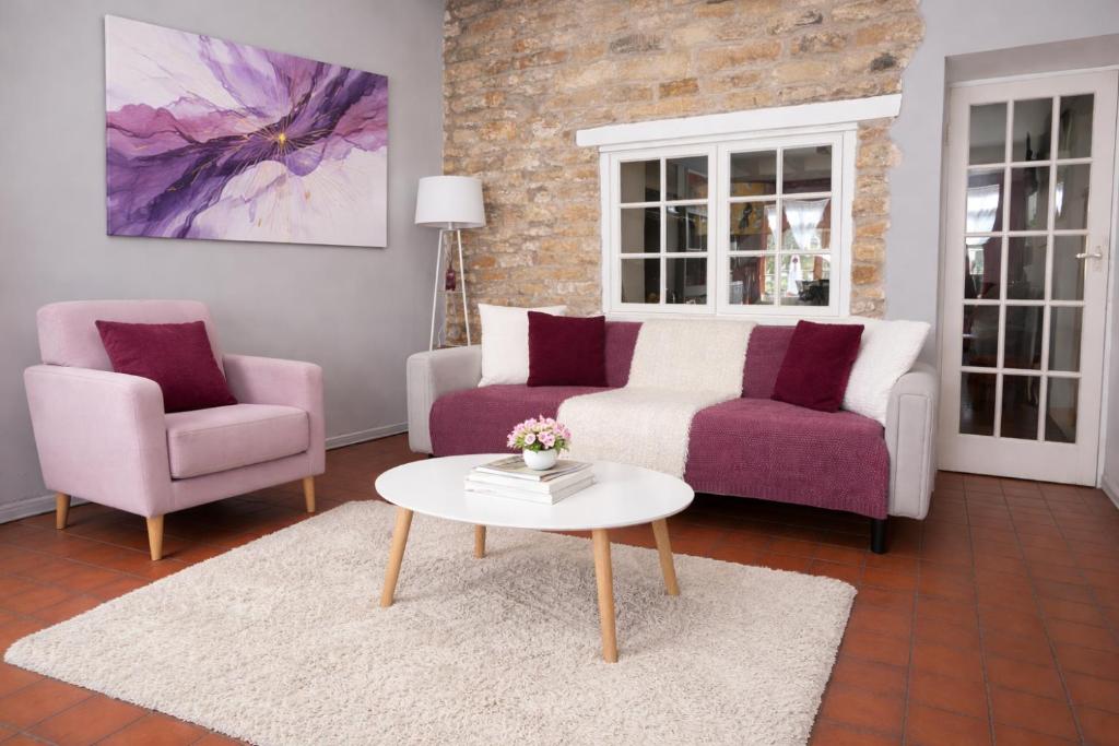 a living room with two chairs and a table at 10 Pudding Bag Lane in Exton
