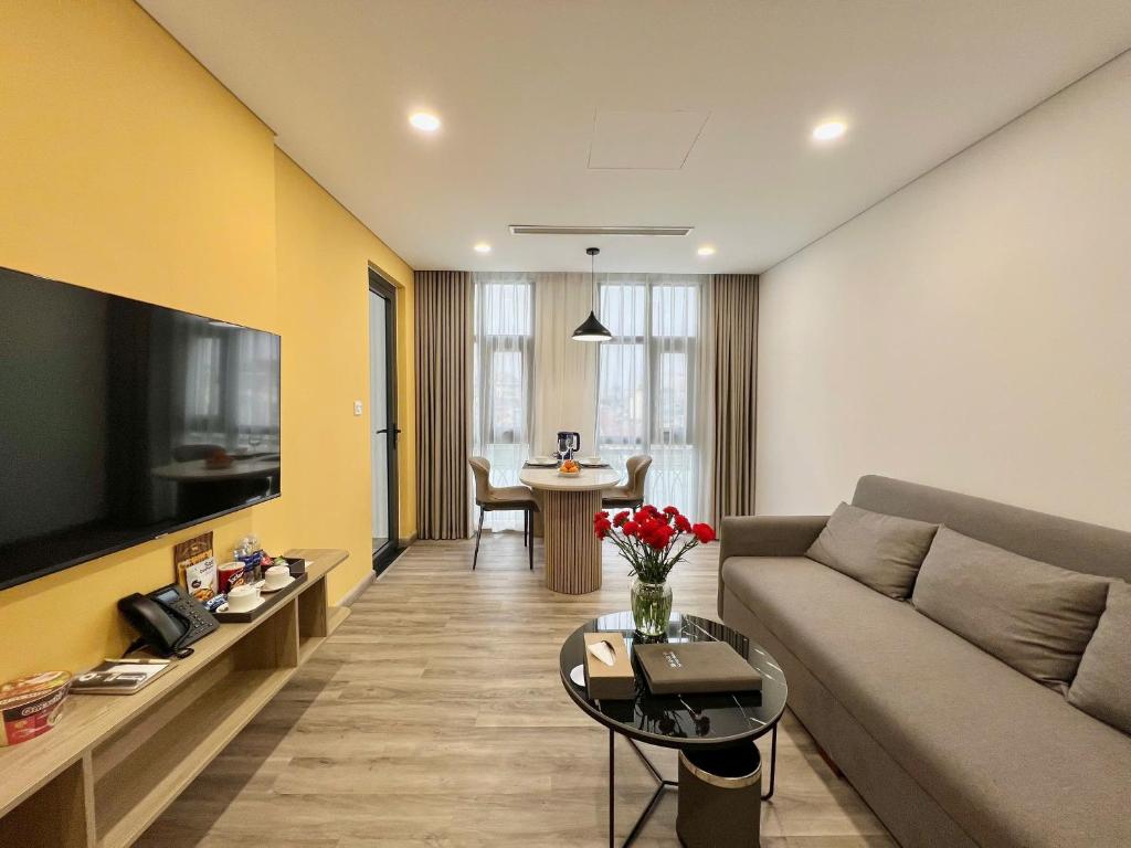 a living room with a couch and a table at GEM Hotel And Residence in Hanoi