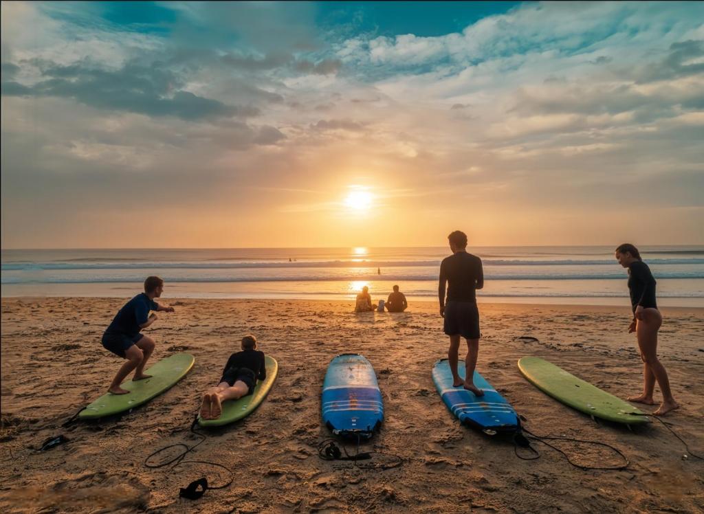 a group of people standing on a beach with surfboards at Zenways in Varkala
