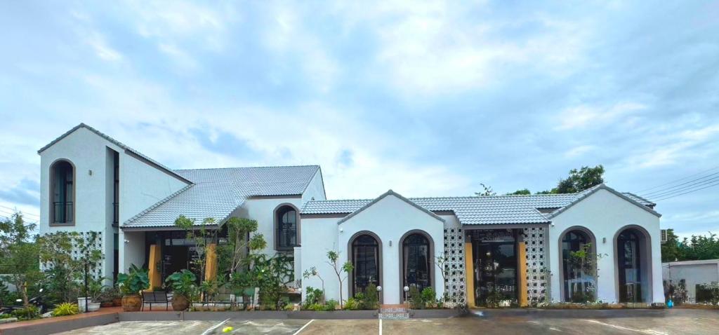 a large white building with a roof at อยู่สบายวิลล่า ยโสธร in Yasothon
