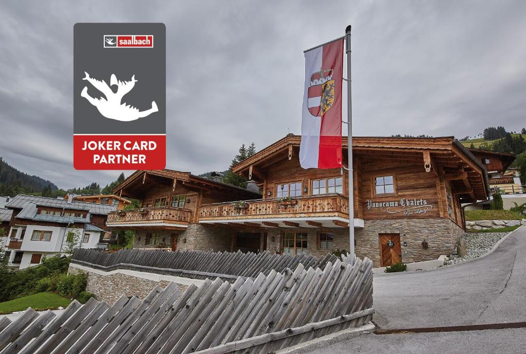 a building with a sign and a flag in front of it at Panorama Chalets by we rent, JOKERCARD INCLUDED in Saalbach-Hinterglemm