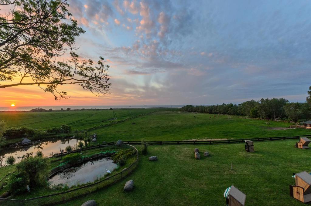 a view of a field with a sunset in the background at Pension Schmelzer in Kägsdorf