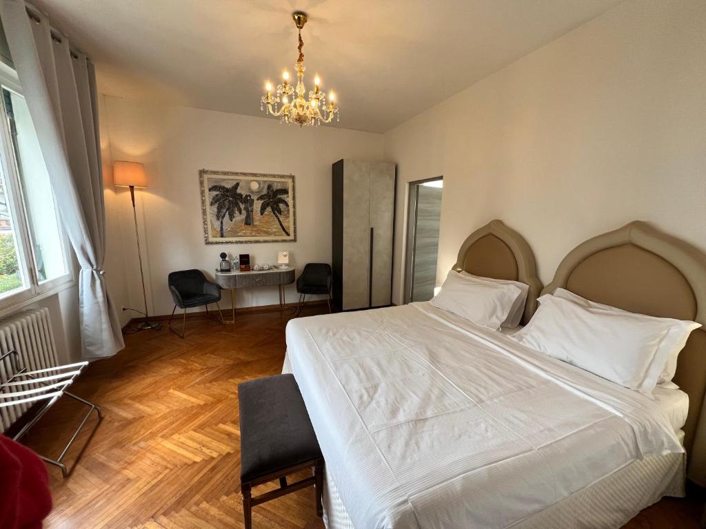 a bedroom with a white bed and a chandelier at Ca Nart in Venice-Lido