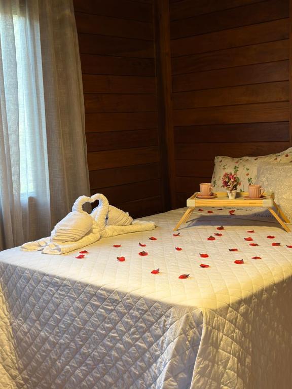a bed with two swans sitting on top of it at Chalé Garden - Pedra Azul in Domingos Martins