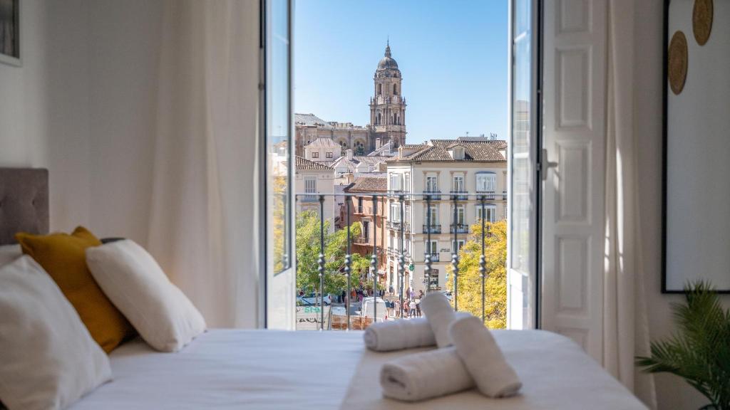 a bedroom with a window with a view of a city at Apartamentos Alcazaba in Málaga