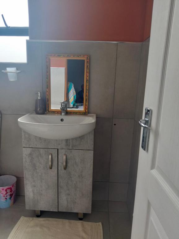 a bathroom with a sink and a mirror at Goodman's Guest home in Nelspruit