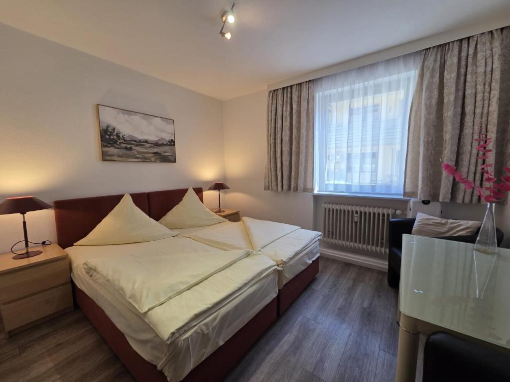 ein Hotelzimmer mit einem Bett und einem Fenster in der Unterkunft Hotel Central in Erlangen