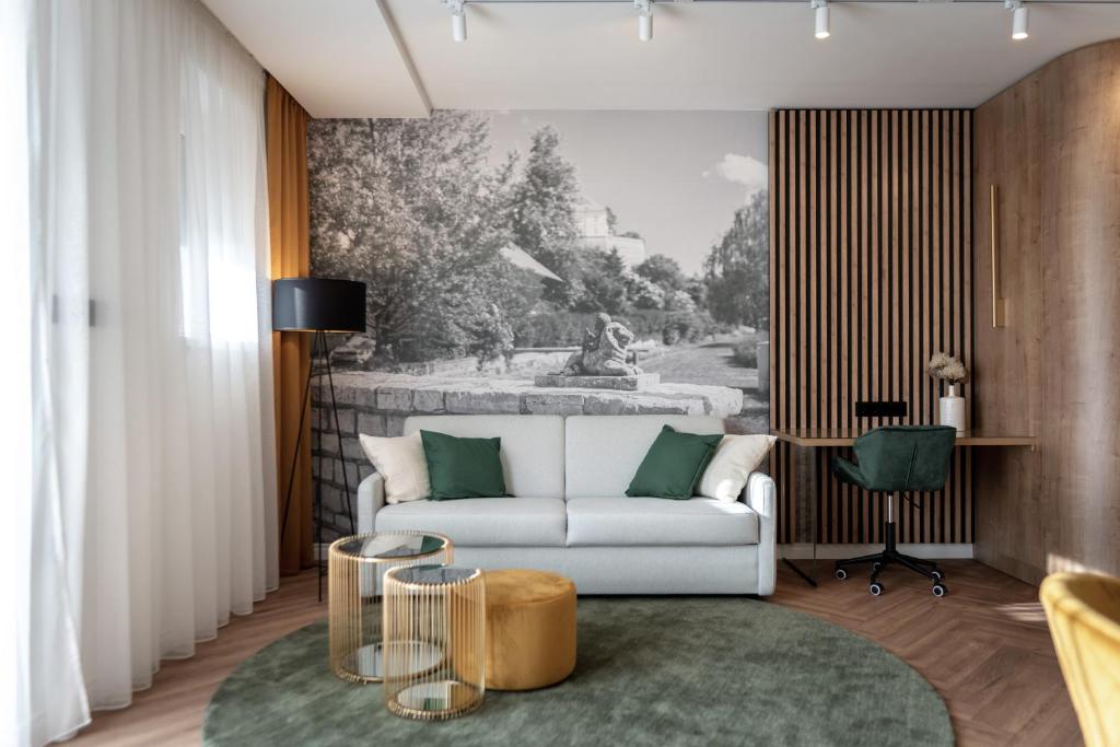 a living room with a white couch and a painting at LEO Apartman in Veszprém