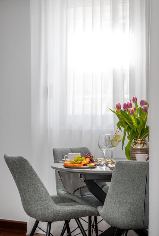 a dining room table with chairs and a plate of food at Vila Pivac in Makarska