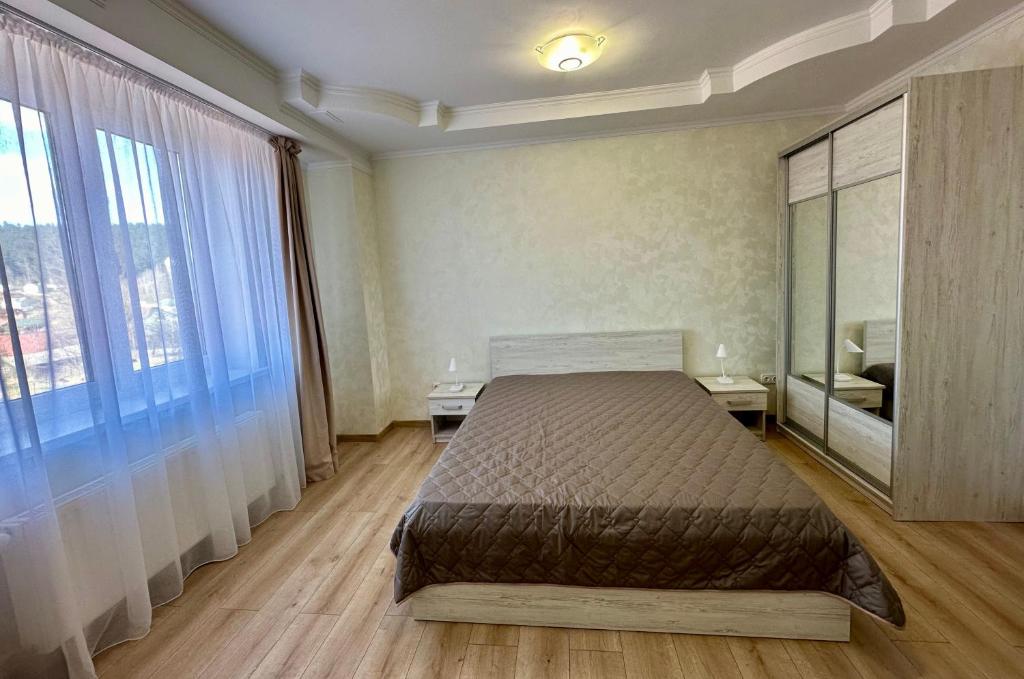 a bedroom with a bed and a large window at Апартаменти Пасаж in Skhidnitsa