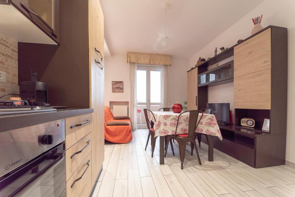a kitchen with a table and chairs in a room at CASE VACANZE ROSA CON SERVIZIO SPIAGGIA in Lido Adriano