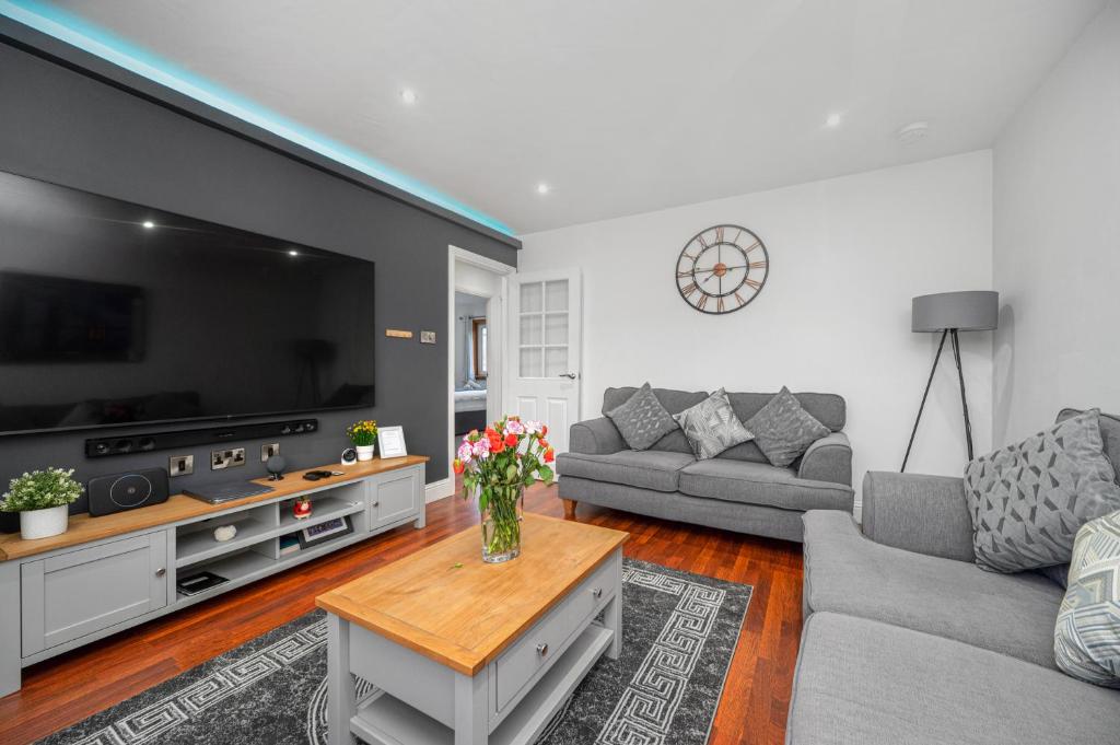 a living room with a large flat screen tv at Leys Park Executive Apartments in Dunfermline