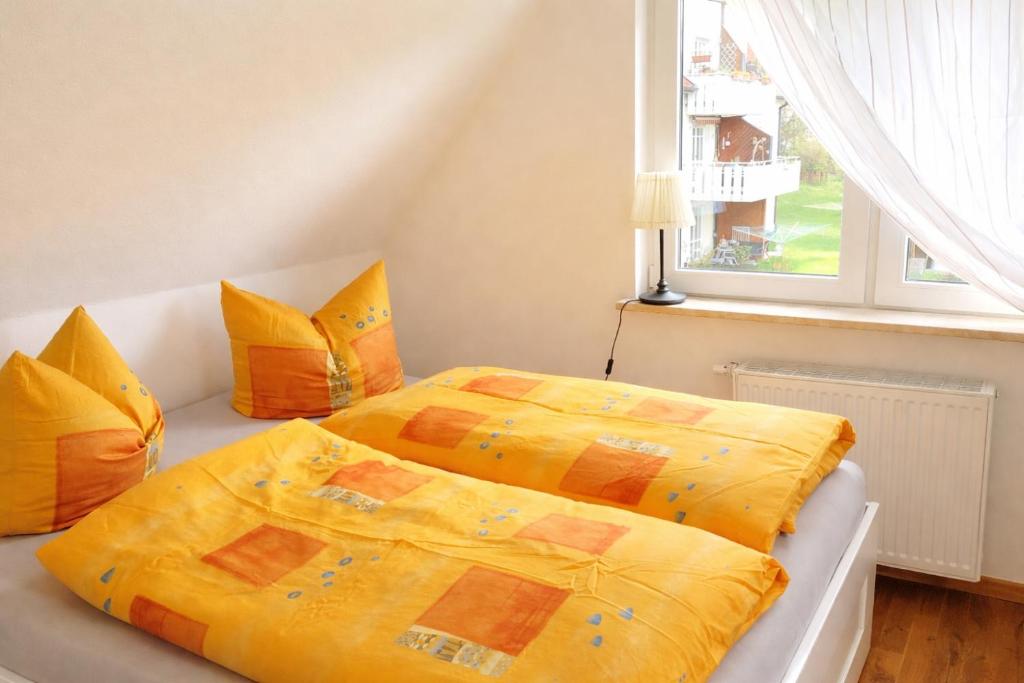 a bedroom with two beds with yellow sheets and a window at Stiegenstübchen am Weinberg in Dresden