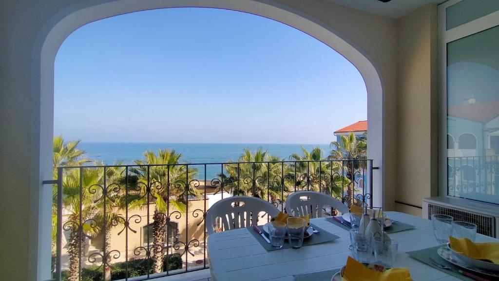 a balcony with a table and chairs and the ocean at Trilocale DIRETTAMENTE SUL MARE CON DUE BAGNI cod 510 in Porto Recanati