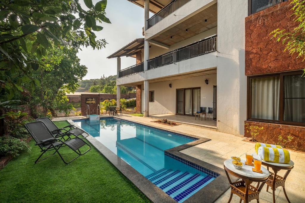 a swimming pool in the backyard of a house at SaffronStays Casa Amore in Mahabaleshwar