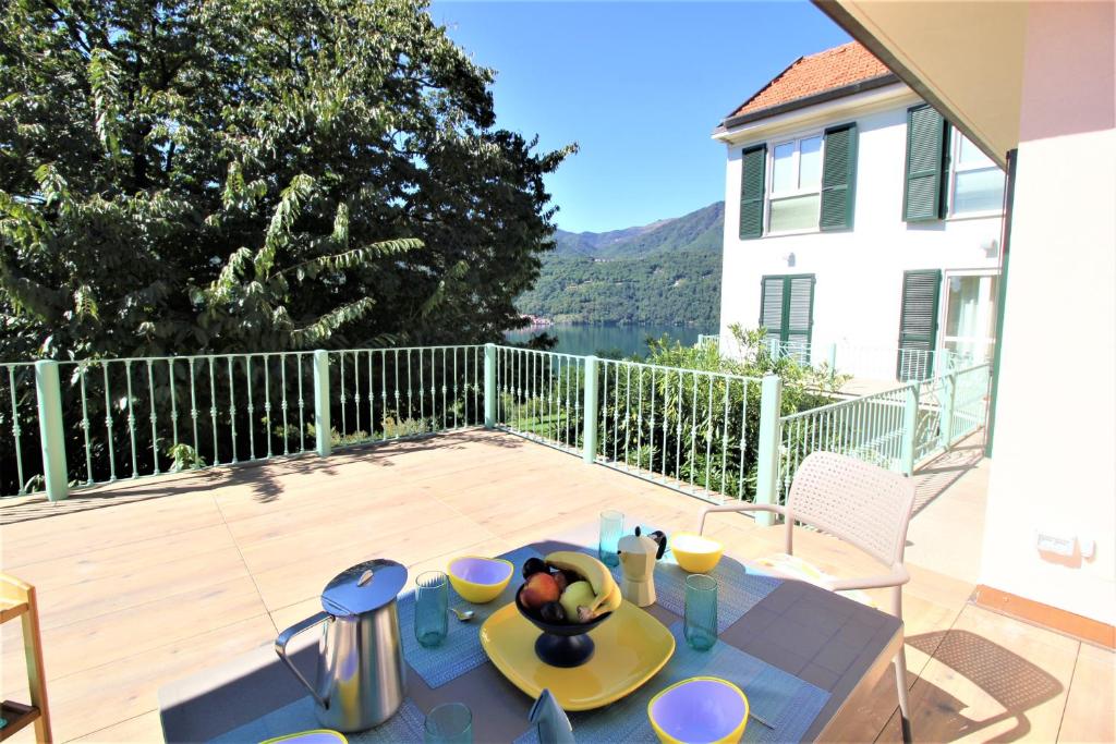 a patio with a table with a bowl of fruit on it at Holiday Home Lake Orta in Pettenasco