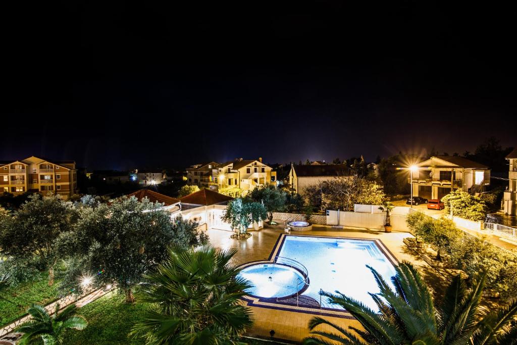 una vista aérea de una piscina por la noche en City Pool Apartments Novalja, en Novalja