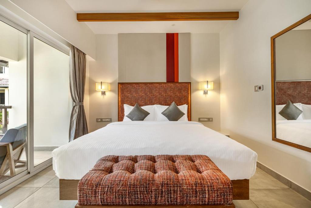 a bedroom with a large bed and a couch at Mango Hill Hotel Velankanni in Velankanni