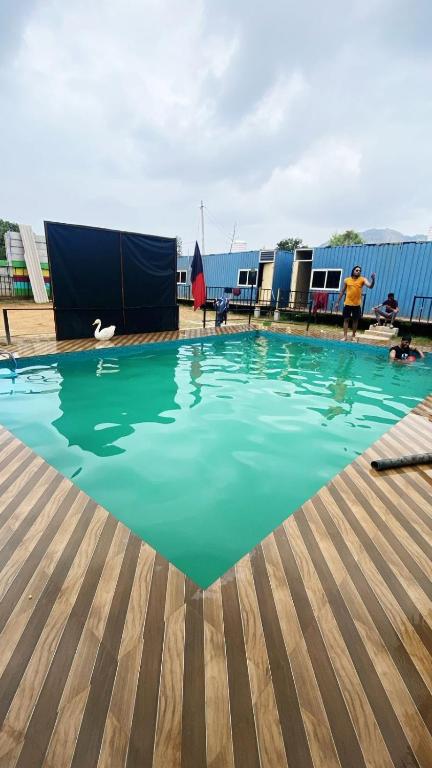 a swimming pool with green water in a building at Rd resort in Jāmb