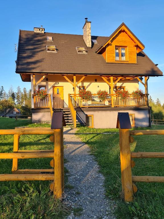 a house with a fence in front of it at Chata Wielki Potok in Istebna
