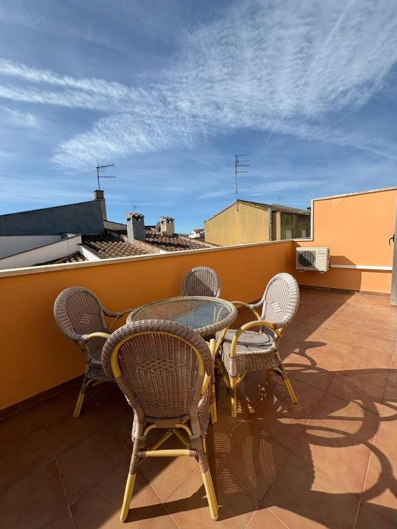 a patio with chairs and a glass table on a roof at Apartament Deportiva in Deltebre
