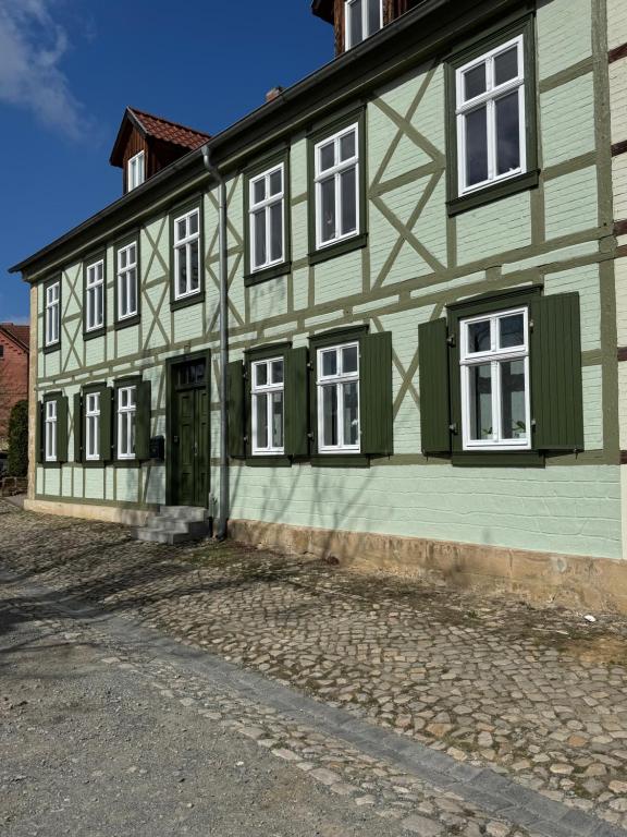 a green and white building with green doors and windows at Ecke - der Romanik in Quedlinburg