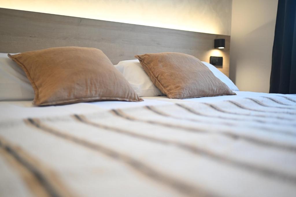 a bed with two pillows on top of it at A Casa da Toura in Puentedeume