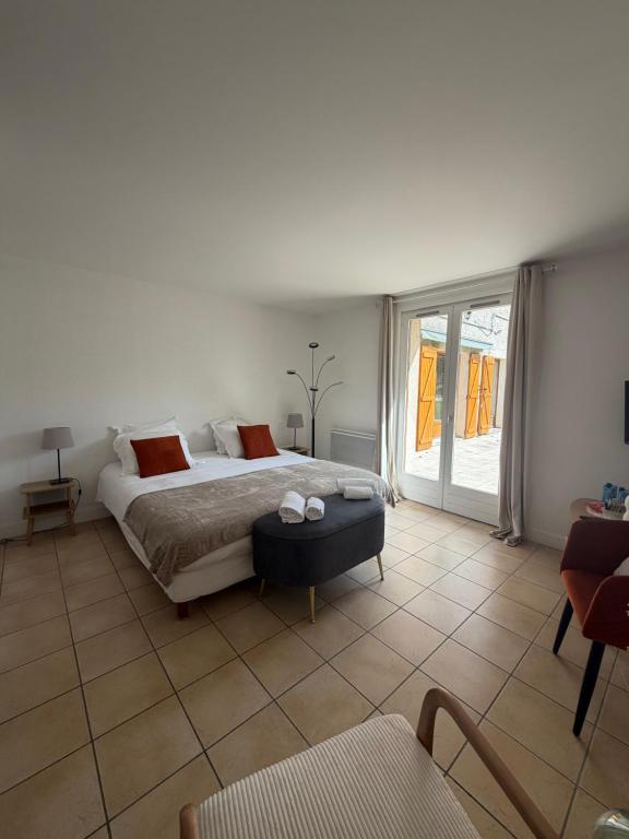 a bedroom with a bed and a large window at Golf Hotel de la Carte in Chouzy-sur-Cisse