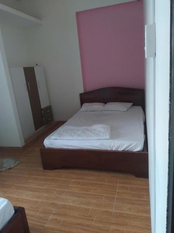 a bedroom with a bed with a pink wall at Homestay846 in Vung Tau