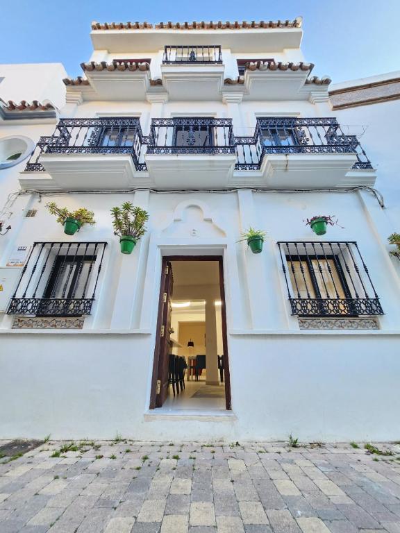 a white building with two balconies and a door at Casa Suspiro in Estepona