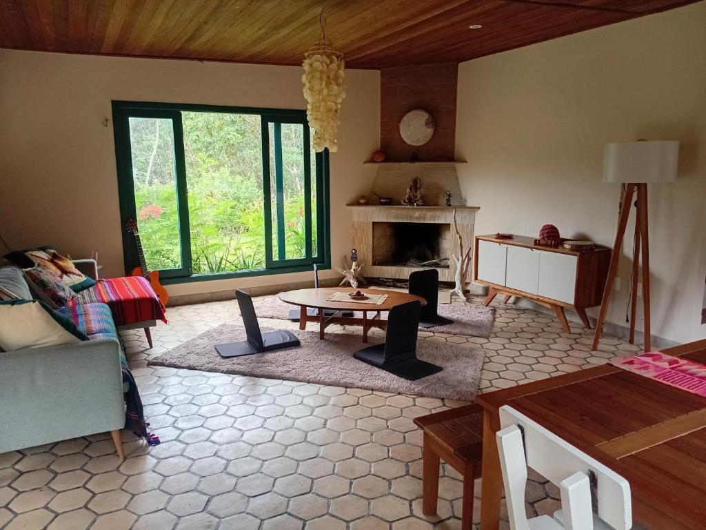 a living room with a table and a fireplace at Casa Morro Branco in Palmeiras
