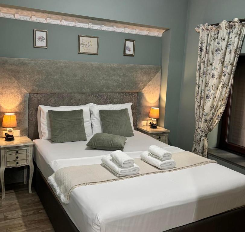a bedroom with a large white bed with two lamps at Green House Skiathos in Skiathos