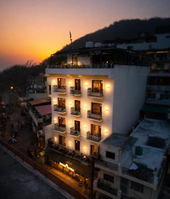 a large white building with a sunset in the background at Shree Vatika in Rishīkesh