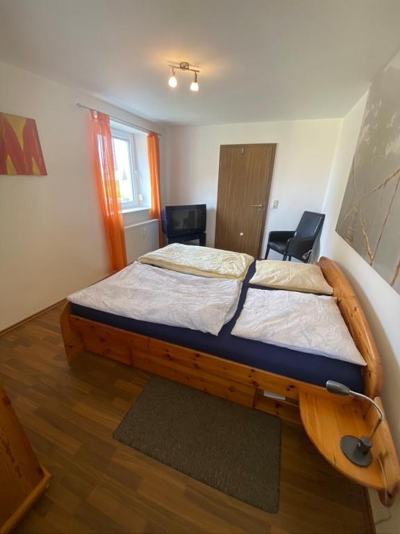 a bedroom with a wooden bed in a room at Fewo 4 in Markkleeberg