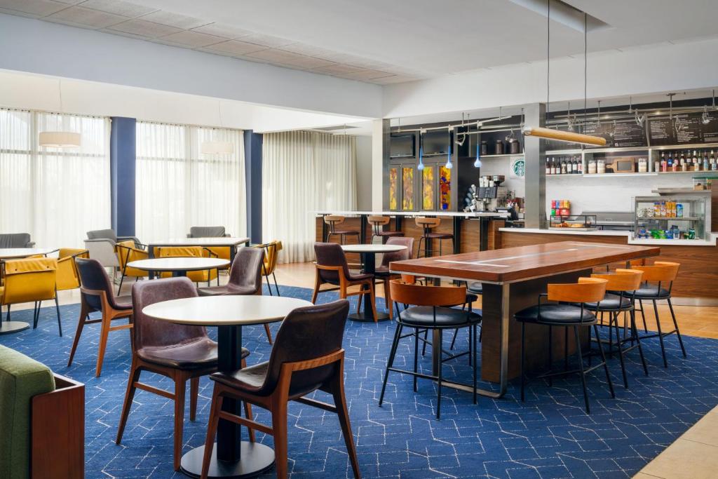 a restaurant with tables and chairs and a bar at Courtyard Columbus Worthington in Worthington