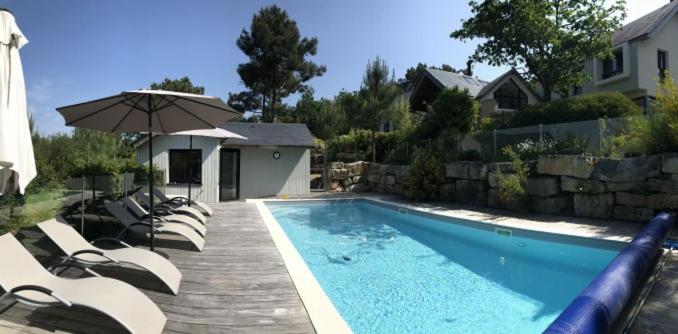 a swimming pool with lounge chairs and an umbrella at Kerlenn in Baden