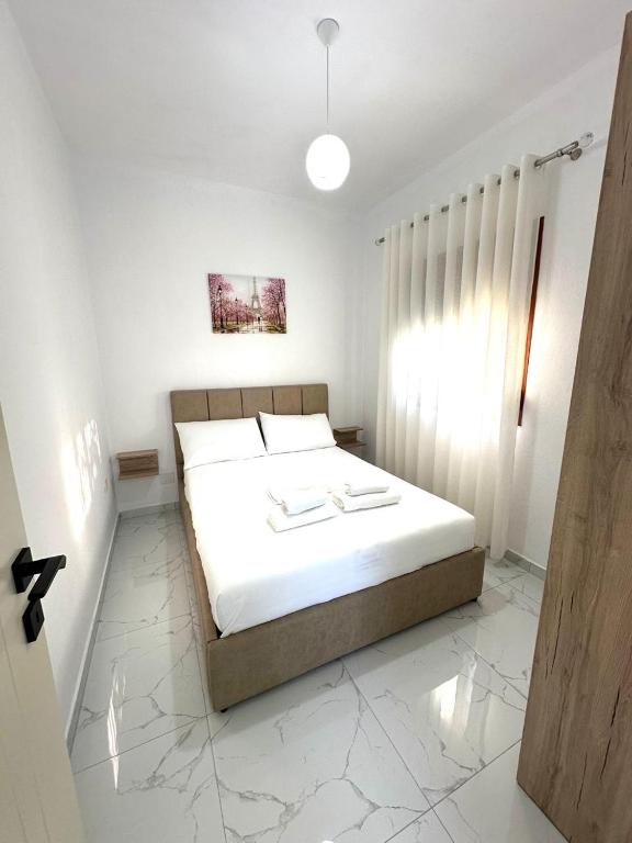 a bedroom with a bed with white sheets at Taku Rooms Vlora in Vlorë