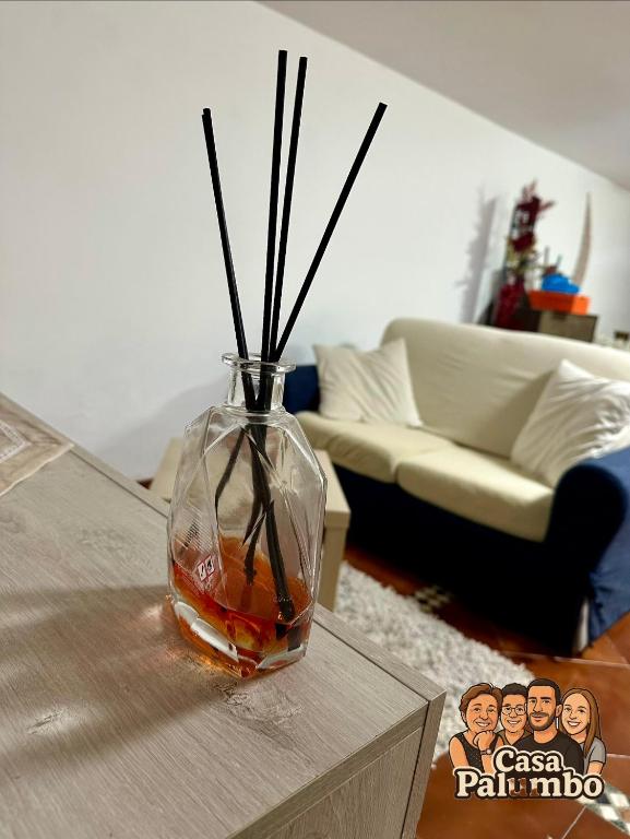 a vase with sticks in it sitting on a table at Casa Palumbo in Bacoli