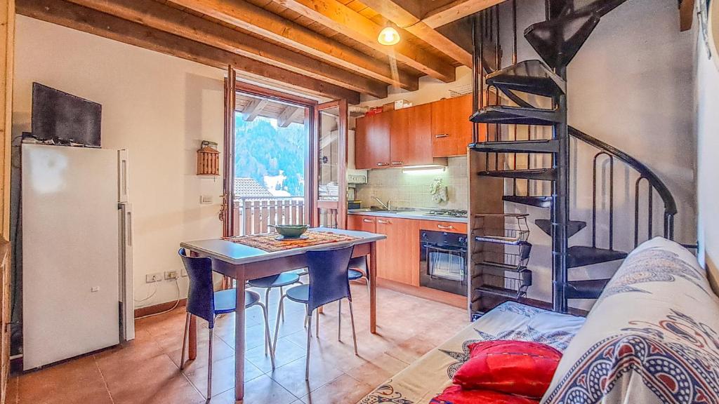 a kitchen with a table and a refrigerator and a ladder at Casa Loca Colere in Colere